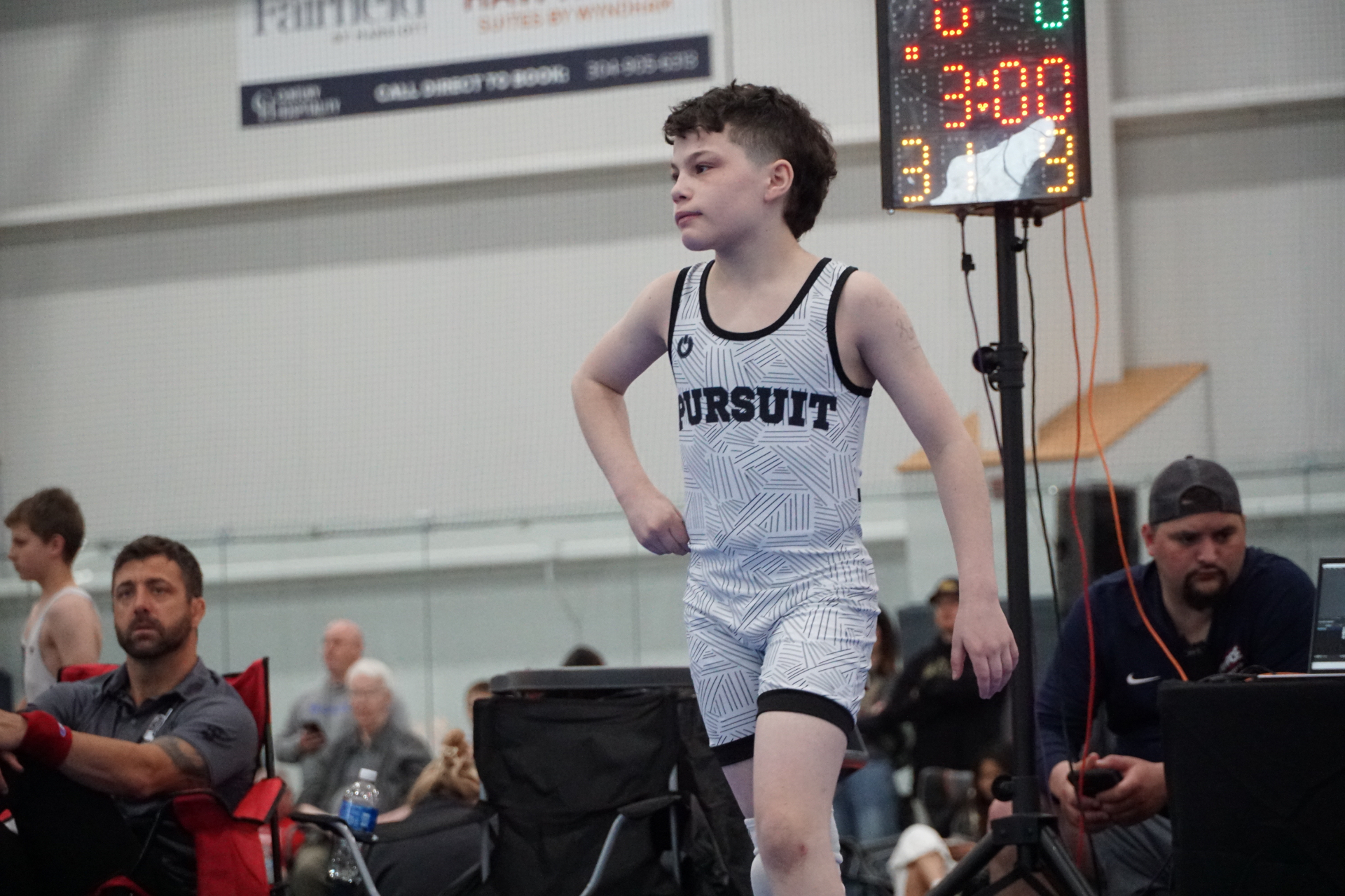 Young wrestler walking near the scoreboard